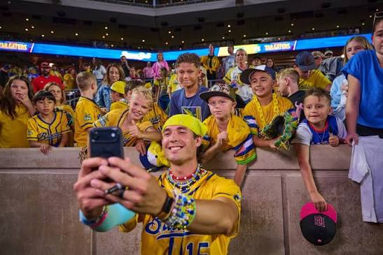 RAC from Savannah Bananas taking a selfie with a group of young fans.